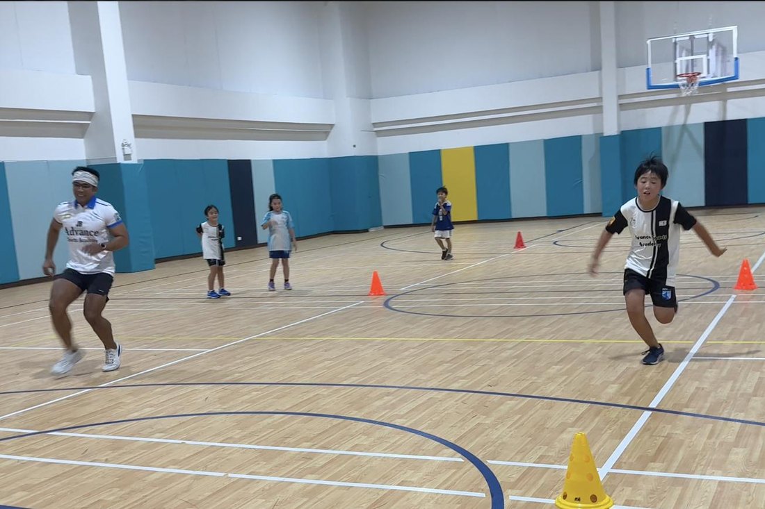 Children sprinting alongside a coach