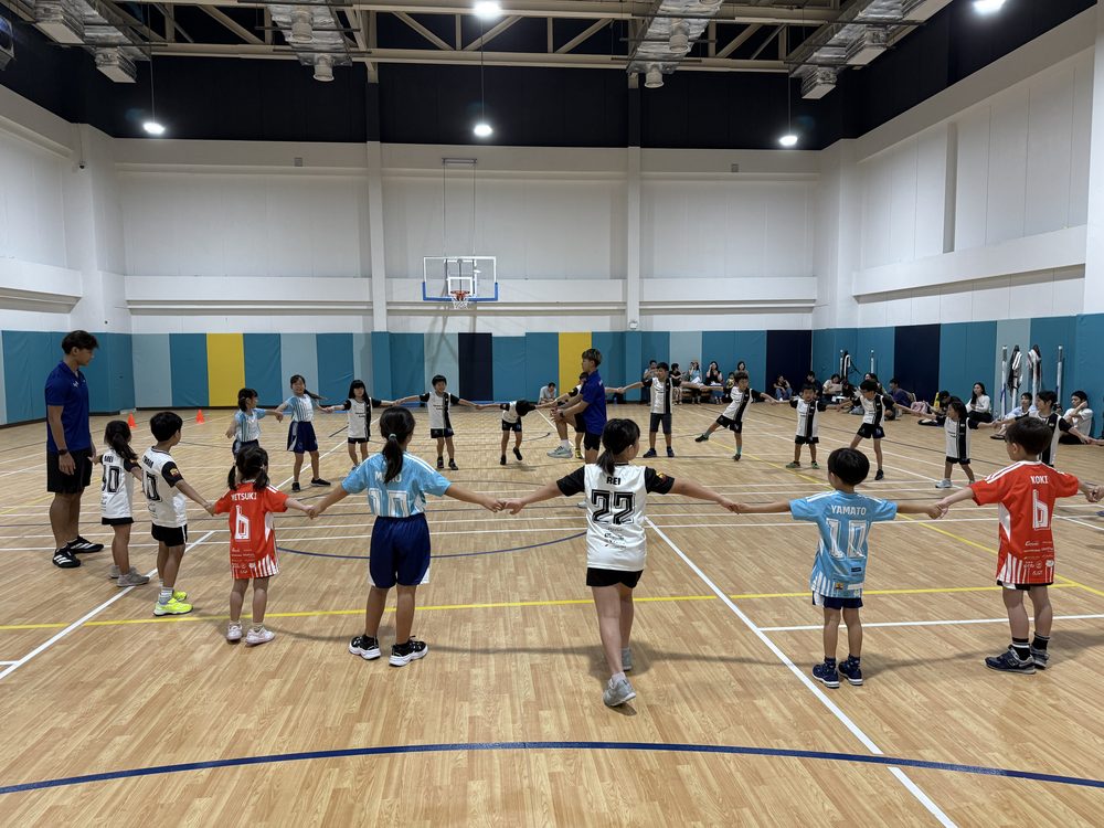 体育館で輪になって運動する子どもたち