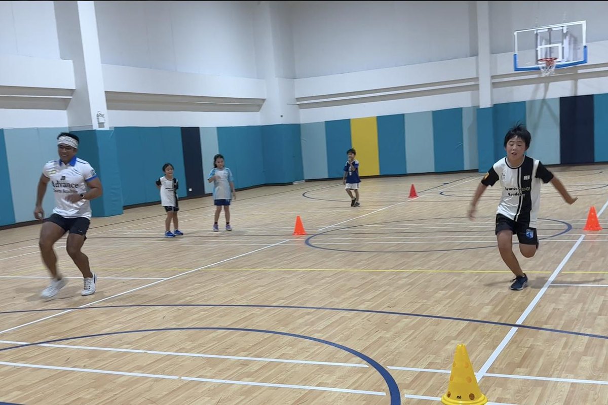Children sprinting alongside a coach