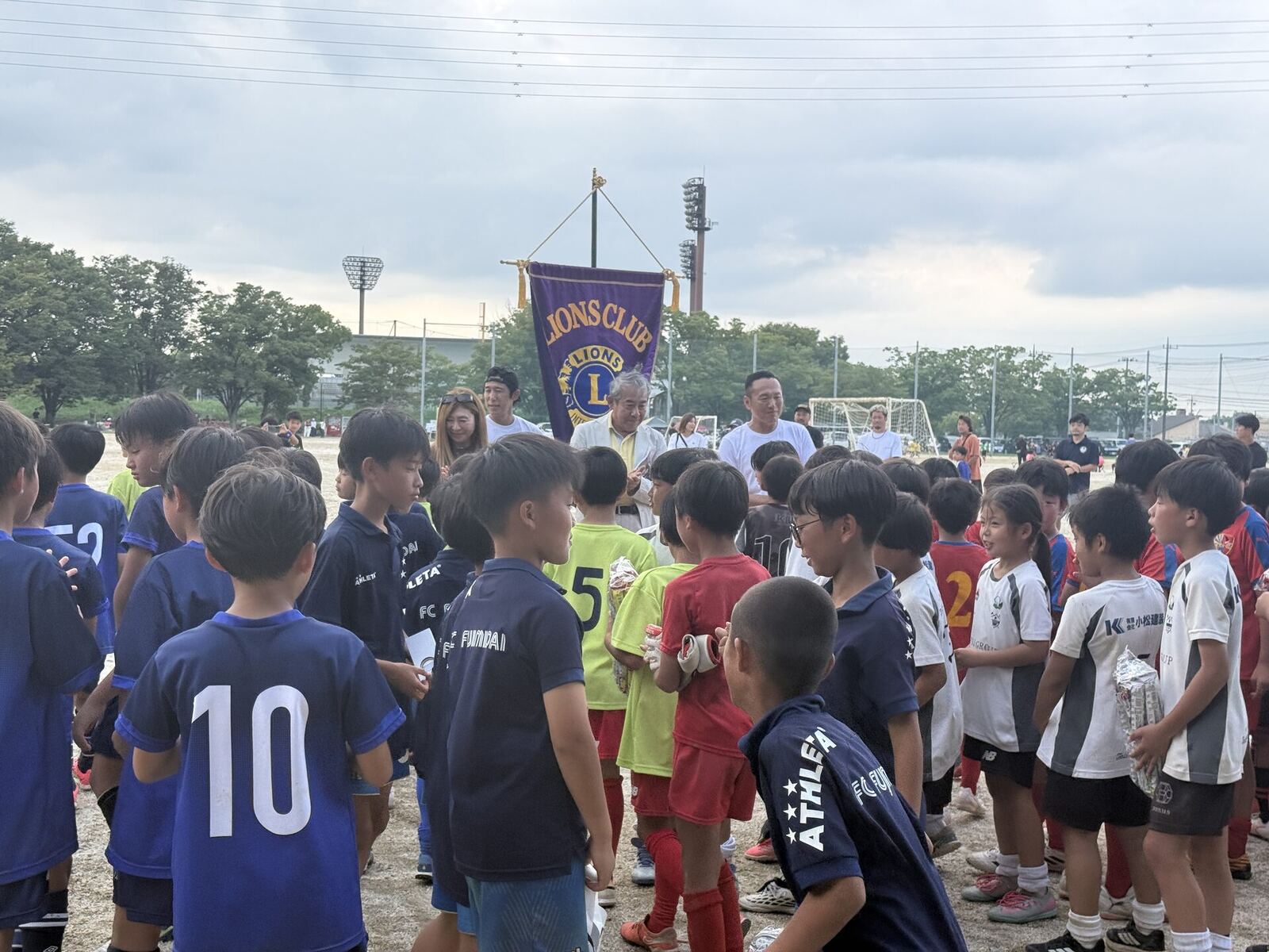 開会にあたり東京HAKUHOライオンズクラブの旗の前に集まる子どもたち