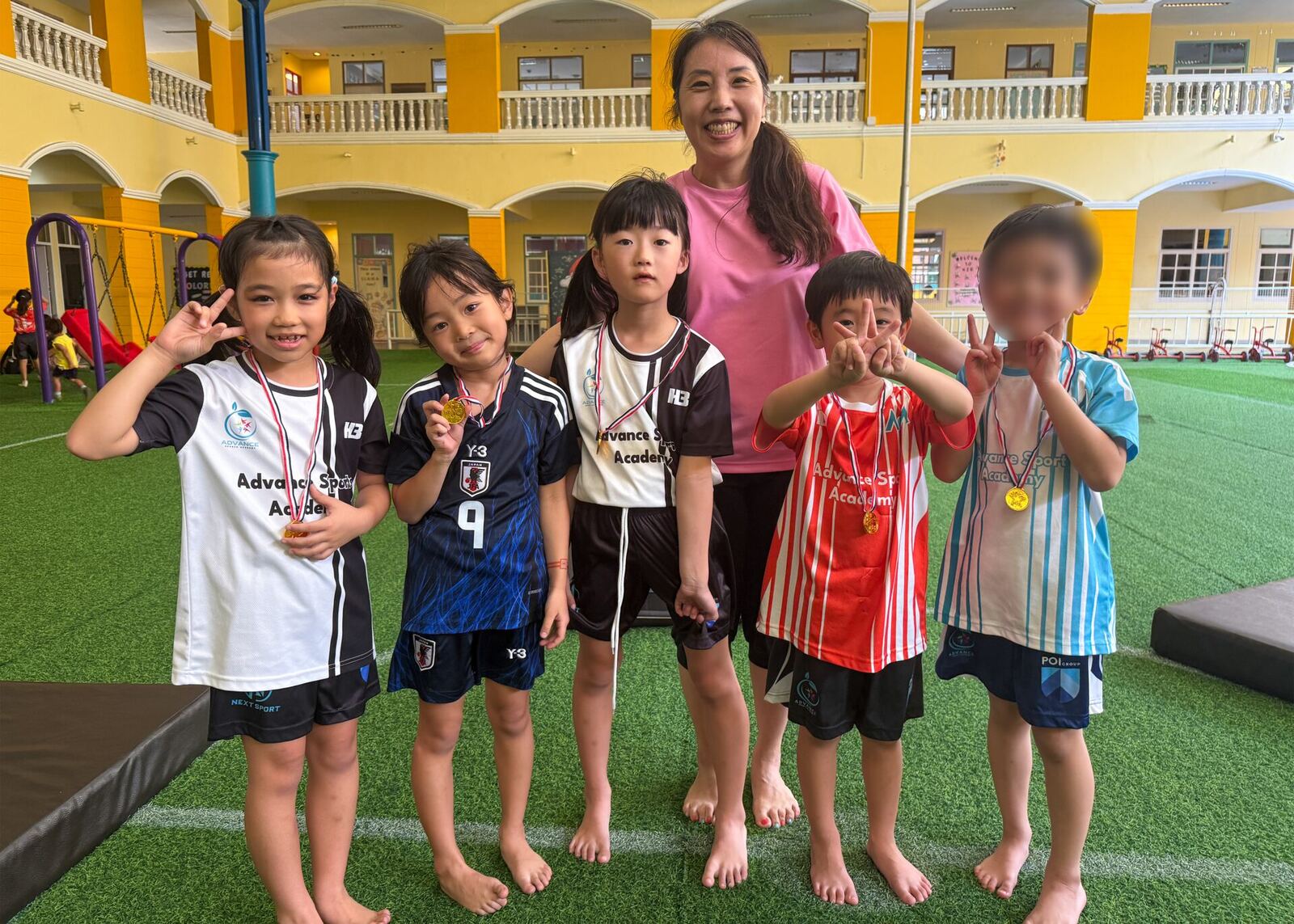 メダルを受け取り笑顔を見せる子どもたちとコーチ