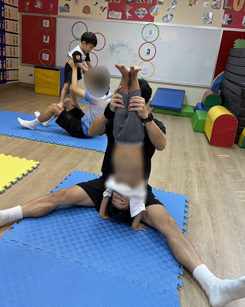 前転に挑戦する子どもとコーチ
