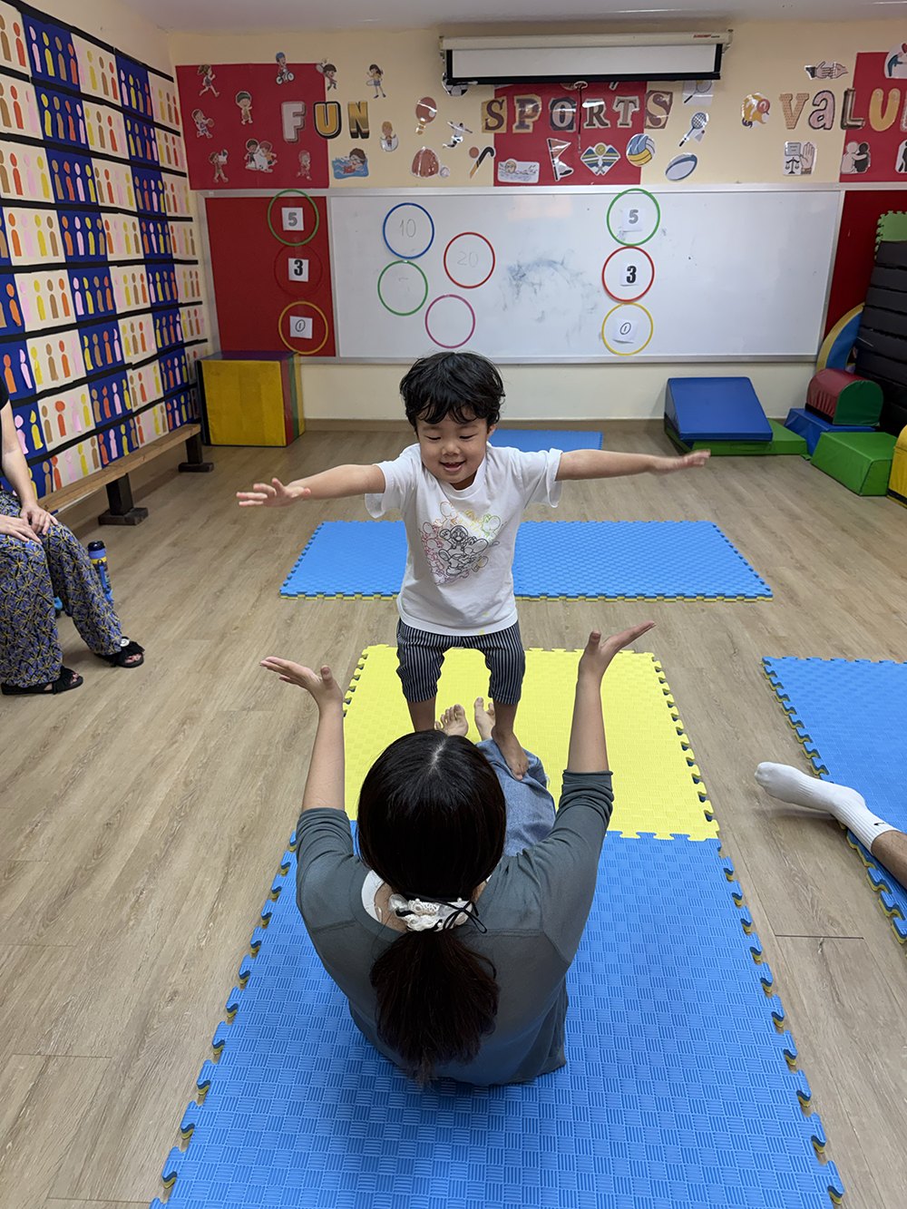 コーチのサポートでバランスをとる子ども
